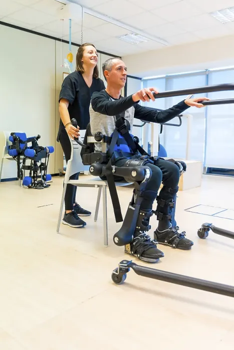 Stampa con cornice : Esoscheletro meccanico. Assistente fisioterapista donna che solleva una persona disabile con scheletro robotico per farla alzare. Stampa con cornice : Esoscheletro meccanico. Assistente fisioterapista donna che solleva una persona disabile con scheletro robotico per farla alzare.