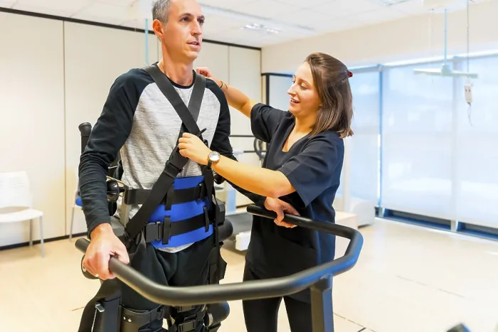 Stampa con cornice : Esoscheletro meccanico. Assistente fisioterapista femminile con persona disabile sollevata con scheletro robotico. Stampa con cornice : Esoscheletro meccanico. Assistente fisioterapista femminile con persona disabile sollevata con scheletro robotico.