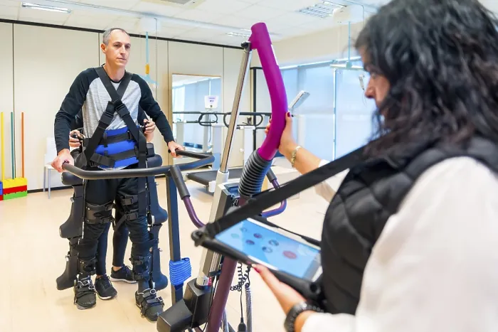 Stampa con cornice : Esoscheletro meccanico. Assistente fisioterapista femminile con persona disabile sollevata con scheletro robotico. Stampa con cornice : Esoscheletro meccanico. Assistente fisioterapista femminile con persona disabile sollevata con scheletro robotico.