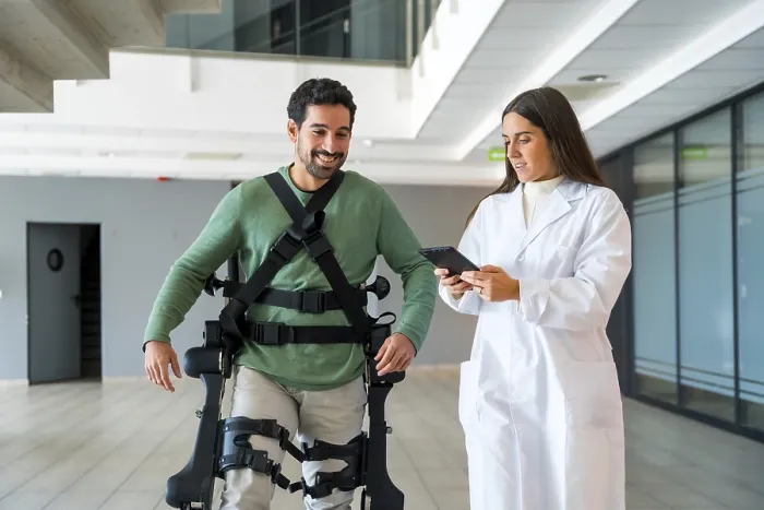 Stampa con cornice : Esoscheletro meccanico, dottoressa fisioterapista donna con persona disabile con scheletro robotico in riabilitazione. Stampa con cornice : Esoscheletro meccanico, dottoressa fisioterapista donna con persona disabile con scheletro robotico in riabilitazione.