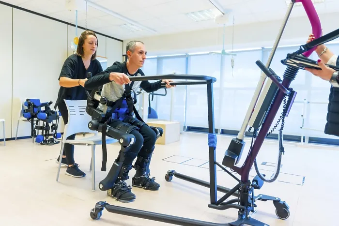 Stampa con cornice : Esoscheletro meccanico. Assistente fisioterapista femminile medico che solleva persona disabile con scheletro robotico. Stampa con cornice : Esoscheletro meccanico. Assistente fisioterapista femminile medico che solleva persona disabile con scheletro robotico.