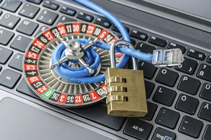 Stampa con cornice : Ruota della roulette, catena e cavo di rete internet stesi sul tastierino del computer simbolizzando l'encryption dei dati. Stampa con cornice : Ruota della roulette, catena e cavo di rete internet stesi sul tastierino del computer simbolizzando l'encryption dei dati.