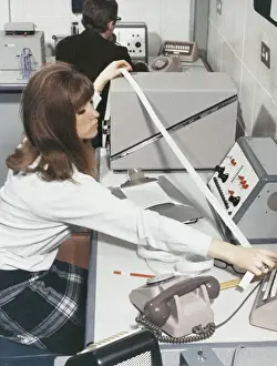 Technician At Work Stampe: A computer technician with data tape