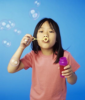 Young Girl Playing Outside Stampe: Blowing bubbles