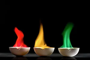 Stampe di Tre piatti in ceramica, ciascuno contenente etanolo bruciante. Ogni piatto ha un fuoco di colore diverso a causa dei chimici aggiunti all'etanolo Immagini datate 2017: Testi di fiamma