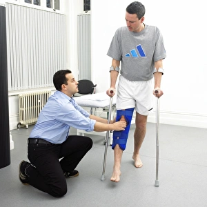 Stampe di Modello rilasciato. Fisioterapia. Il fisioterapista valuta la mobilità nel ginocchio di un paziente. Il paziente indossa una brace per immobilizzare il suo piede dopo un'infortunio Immagini datate 2006 gennaio: Physiotherapy