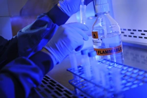 Scientist In Lab Coat Stampe: Scientist decanting ethanol
