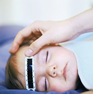 Stampe di È stato rilasciato un modello di autorizzazione. Si sta prendendo la temperatura del bambino di 8 mesi mentre dorme utilizzando uno strumento termografico a strippa per misurare la sua temperatura Immagini datate 2007 maggio: Prendere la temperatura del bambino