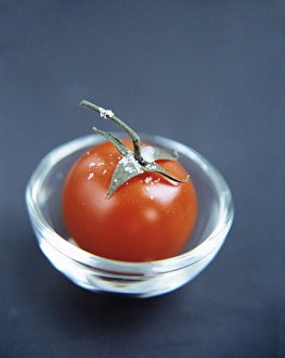 Stampe di Il pomodoro (Lycopersicon esculentum) in un bicchiere di vetro. Questo frutto ha molti usi nella cucina e è una buona fonte di vitamine A e C Immagini datate 2004 agosto: Tomato