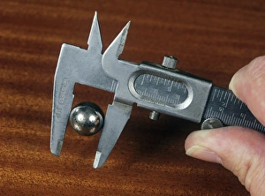 Stampe di Utilizzando calatelli Vernier. Questo dispositivo di misurazione viene utilizzato per misurare il diametro di un bullone metallico a sfera. Le estremità esterne vengono utilizzate Immagini datate 2006 febbraio: Utilizzando misuratori di verniera