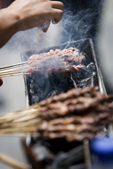 Aggiungendo spezie al barbecue di Kunming in Cina meridionale nella regione del Yunnan nellAsia