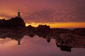Corbiere Lighthouse Jersey Stampe: Dramatic sunset and low tide, Corbiere lighthouse, St. Ouens, Jersey, Channel Islands