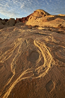 Erosion Patterns In Rocks Stampe: Erosion pattern in yellow sandstone under patterned clouds