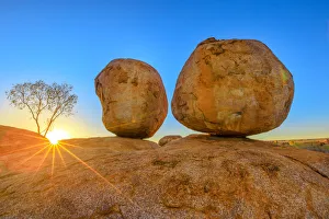 Stampe di Luce del tramonto raggi di Sole a Devils Marbles i Uova della serpente arcobaleno mitologico al Karlu Karlu (Marble dei Diavoli ) Riserva per la conservazione Immagini datate 2019 novembre: Raggi di luce del tramonto a Devil's Marbles