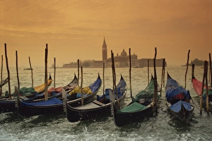 Gondolas In Venice Stampe: View past docked gondolas towards St. Marks Square, from across the Grand Canal