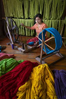 La donna avvolge la spola a un laboratorio di tessitura sul lago Inle, contea di Nyaungshwe.