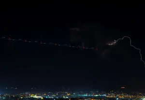Un sentiero lasciato da un elicottero è visto vicino ad una tempesta elettrica vista dalla città di Mdina