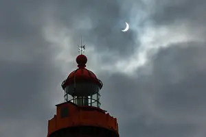 Brittany Coast Scenery Stampe: Solar eclipse in a cloudy sky above the lighthouse at Pointe Saint-Mathieu