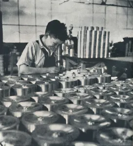 Air Transport Industry Stampe: Apprentice with microscope (testing the hardness of pistons), 1941. Artist: Cecil Beaton