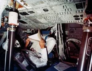 Manned Spaceflight History Stampe: An astronaut inside a NASA Command Module, 1970s. Artist: NASA