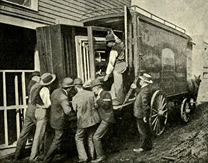 Historic Transportation Methods Stampe: Loading The Camera On A Van For Removal, 1901. Creator: Unknown