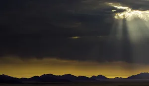 Desert Mountain Scenery Stampe: the sun breaks through the clouds in namibia, Namibia