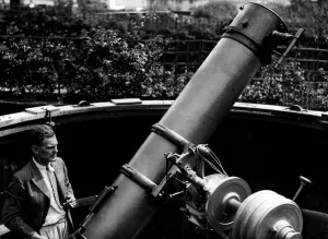 Lattore Will Hay visto qui con il suo telescopio da 12 e mezzo piedi nel giardino dietro casa.