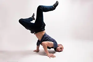 Stampe di Ballerino elegante che esegue figure di breakdance. In piedi su entrambe le mani, testa giù e entrambe le gambe in alto Arte Di Strada Stampe: Ballerino elegante che esegue figure di breakdance.