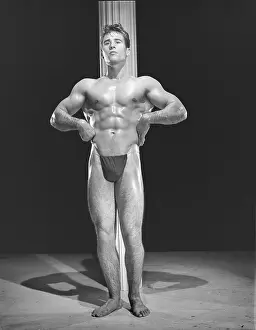 Black And White Muscular Men Stampe: Bodybuilder Poses In Front Of Pole c.1954