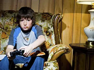 Stampe di Ragazzo con controller del videogioco sul divano Maggio Stampe: Ragazzo con controller del videogioco sul divano.