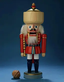Christmas Celebration Decorations Stampe: Close-up of a nutcracker with a walnut beside it