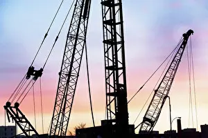 Building Site Equipment Stampe: Construction cranes at sunset