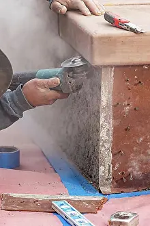 Construction Manpower Stampe: Construction worker using grinder at construction site