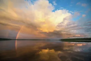 Tranquil Lake Scenery Stampe: A rainbow and a dramatic cloud formation over a lake