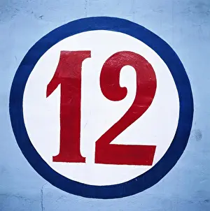 Stampe di Dodici numerico scritto in cerchio su parete blu Luglio Stampe: Dodici numerico scritto in cerchio su parete blu.