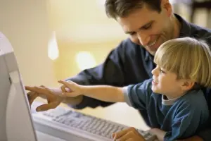 Stampe di Profilo laterale di un padre e suo figlio che utilizzano un computer 2002 Stampe: Profilo laterale di un padre e suo figlio che utilizzano un computer.