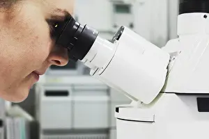 Scientific Experiment Stampe: Scientist looking through microscope