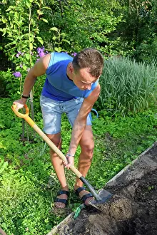 Young Gardener Stampe: A young man digging a flower bed on the plot A young man digging a flower bed on the plot