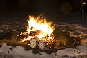 Deserted Snowy Landscape Stampe: 2 cups standing in front of a campfire