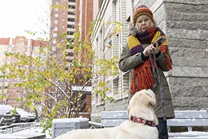 Purebred Dog Head Shot Stampe: Affection Moment. Outdoor winter scene where woman shares tender moment with pet dog surrounded by snow and bare trees