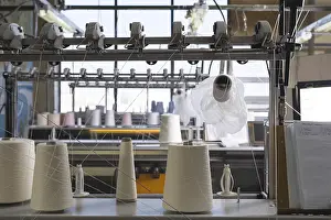 Industrial Building Architecture Stampe: Big spools with white thread at rewinding machine view