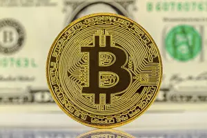 Cryptocurrency Symbol Stampe: Bitcoin with dollar bill in the background