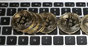 Cryptocurrency Symbol Stampe: Bitcoins on Computer Keyboard Background