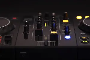 Professional Audio Equipment Stampe: A black DJ mixer with various buttons and knobs