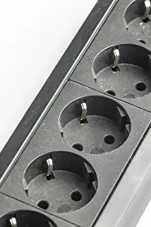 Power Industry Equipment Stampe: Part of a black plastic socket strip with empty sockets