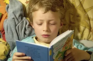 Education For Kids Stampe: Boy reading in bed