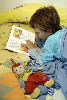 Boy Reading In Bed Stampe: Boy reading in bed