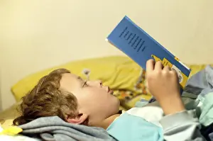 Boy Reading In Bed Stampe: Boy reading in bed
