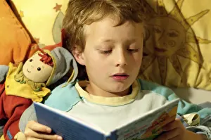 Boy Reading In Bed Stampe: Boy reading in bed