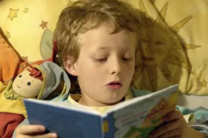 Boy Reading In Bed Stampe: Boy reading in bed